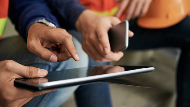 Two people pointing at a tablet