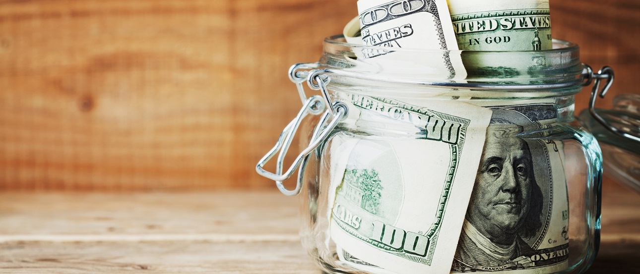 Large ddollar bills rolled and placed in a mason jar