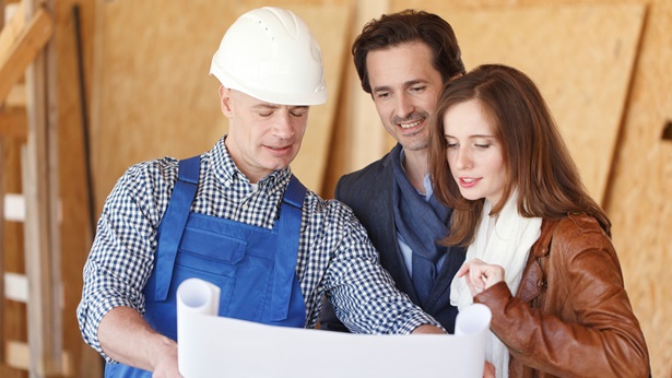 A couple and a contruction worker looking at blue prints