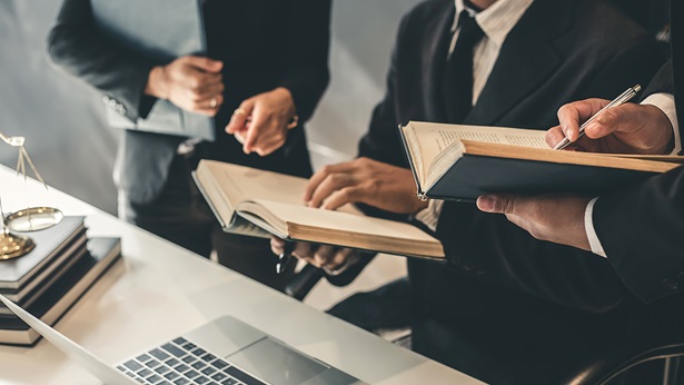 People in suits discussing and writing in notebooks