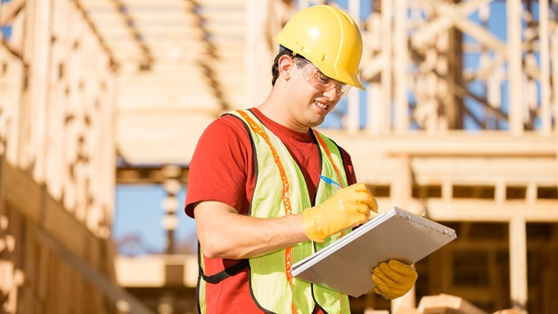 Construction worker on site writing notes